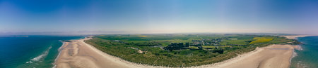UK, England, Northumberland, Bamburgh Castle on hill near beachの写真素材