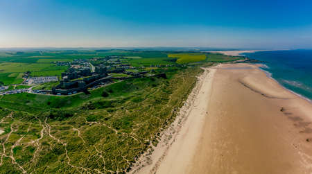 UK, England, Northumberland, Bamburgh Castle on hill near beachの写真素材