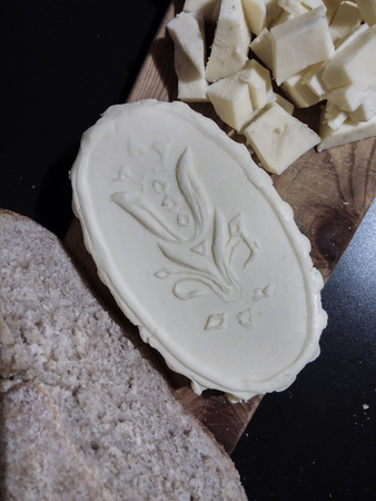 Cutting board with homemade butter, rye bread made with yeast and Toma cheeseの写真素材