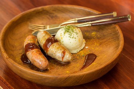 Home made sausage with Mashed Potatos on wooden plateの写真素材