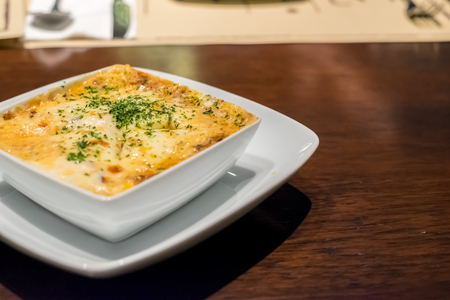 Lasagna in plate on wooden tableの写真素材
