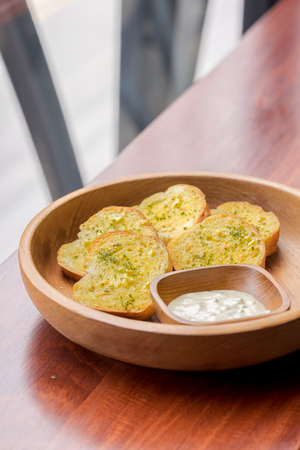 Cheese garlic bread in wooden plateの写真素材