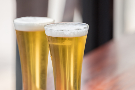 Glass of Beer on wooden table in restaurantの写真素材