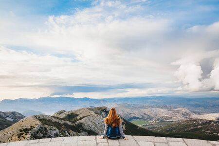 Girl with red hair looking into the distanceの写真素材