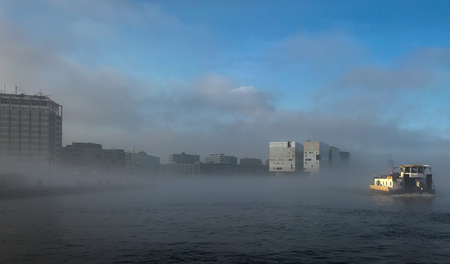Boat in the mist in Amsterdam harbour in the Netherlandsの写真素材