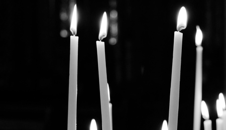 black and white picture of candles in a church in valkenburg the netherlandsの写真素材