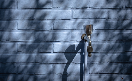 Faucet against a blue wall on a camping outside in ommen the netherlandsの写真素材