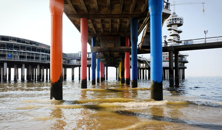 Low angle view on poles of a pier in the sea in the summer in scheveningen, the netherlandsの写真素材