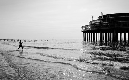 Low angle view on poles of a pier in the sea in the summer in scheveningen, the netherlandsの写真素材