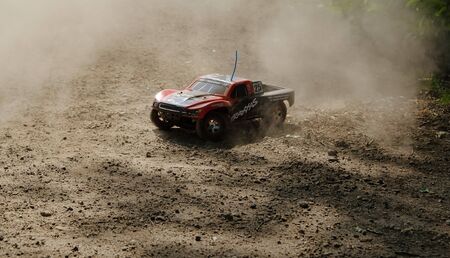 radio controlled monster truck performing a trick at high speed jumps over a large pile of sand. soft focus and beautiful bokeh in amsterdam the netherlandsの写真素材
