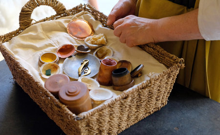 womens hands at basket with antique Roman bathsupplies at the roman baths in bath england uk