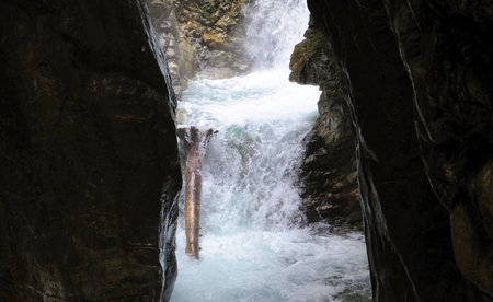 wooden walkpath as bridge over cascading waterfall in austriaの写真素材