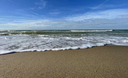 waves of the sea turn against a breakwater in the netherlandsの写真素材
