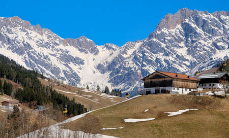 house in the mountains in the snow in the winter in austriaの写真素材