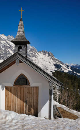 church in the snow sun underneath a blue skyの写真素材