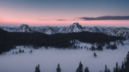 Sunset in the mountains with fog and clouds in the foreground.の写真素材
