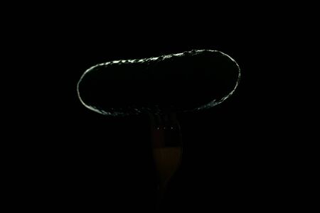 Fresh, green cucumber on fork isolated on black background for salad. Healthy eating concept.の写真素材