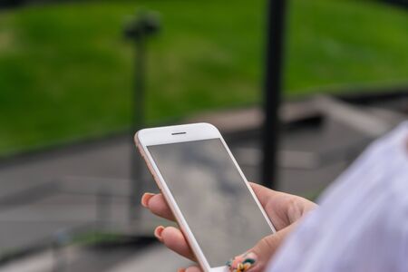 Woman using smartphone in the European city. Hipster girl browsing Internet on a phone, texting and communicating outdoors. Travel conceptの写真素材