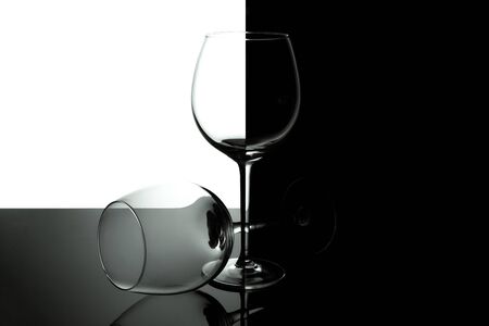 Clean Empty wine glasses with reflections on black and white background. Alcohol beverage card backdrop.の写真素材