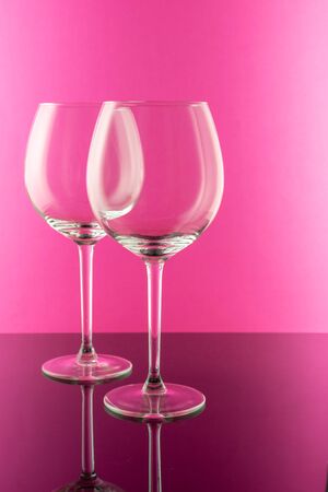 Studio shot of a glass of red wine isolated on pink background closeup. Clean and minimal. Red wine in a big glass. Wine concept.の写真素材