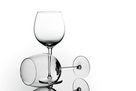 Clean Empty wine glasses with reflections on white background. Alcohol beverage card backdrop.の写真素材