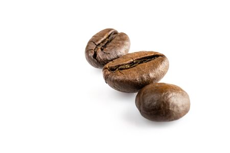 Three shiny fresh roasted coffee beans isolated on white background. Coffee background or texture concept.の写真素材