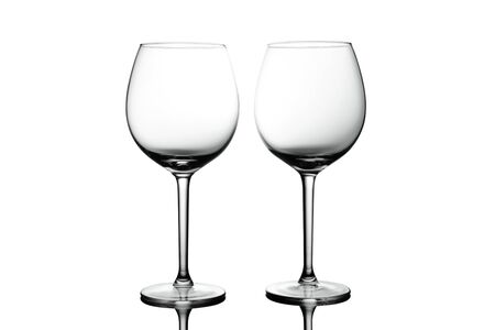 Clean Empty wine glasses with reflections on white background. Alcohol beverage card backdrop.の写真素材