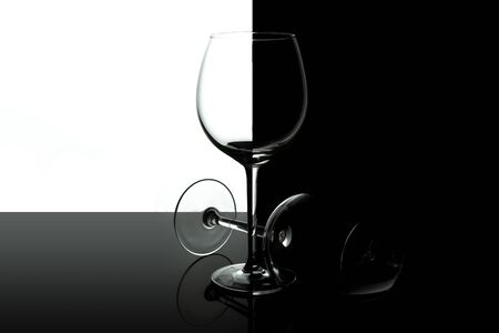 Empty wine glasses for wine isolated on black and white background. Wine list design menu with copy space. Alcohol beverage card backdrop.の写真素材