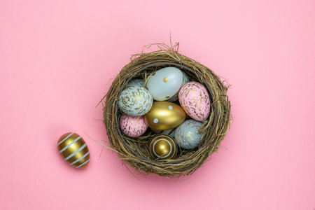 Easter basket. Colorful shine decorated eggs in basket isolated on pink background. Greeting card...