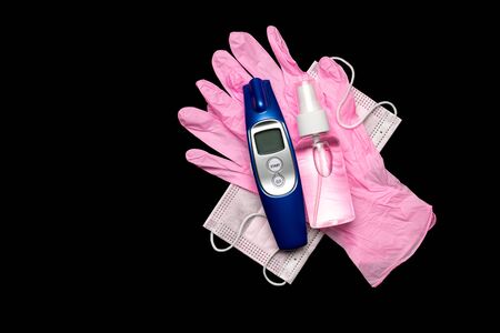 Protection covid. Medical respirator bandage face sanitizer gel, Electronic thermometer and lab gloves - Virus protection equipment on black background.の写真素材