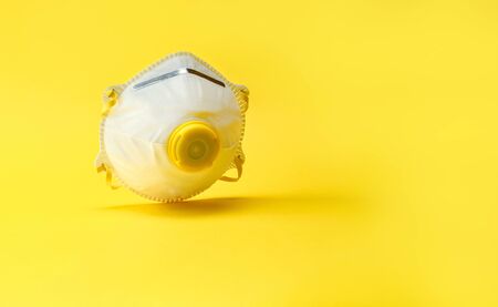 Coronavirus disease COVID-19 medical virus protection. Medic safety filter mask on yellow background. Dangerous asian ncov corona virus, dna, pandemic risk background designの写真素材