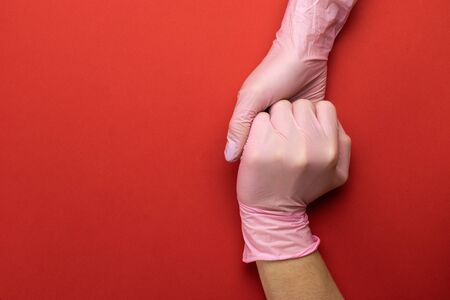 Using Medical lab gloves on hands with medical sanitizer gel. Virus protection equipment on red. Coronavirus Preventive Measures. Professional safety and hygiene for surgery.の写真素材