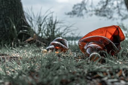 Ecology background. Plastic waste rubbish in forest, woodland. Garbage trash in environment. Empty used dirty bottles. Ecological problemの写真素材