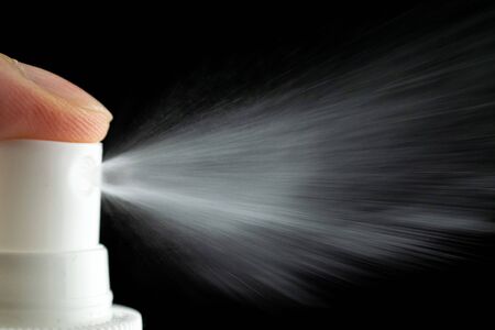 Splash water liquid background. Mist spray aerosol bottle for perfume isolated on blackの写真素材
