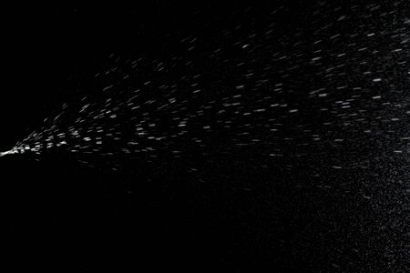 Splash water liquid background. Mist spray aerosol bottle for perfume isolated on blackの写真素材