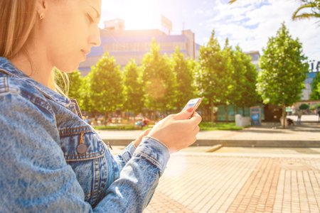 Stylish woman landscape. Happy young girl with phone smile, typing texting and taking selfie in...