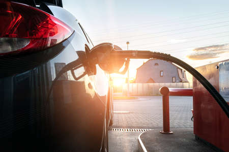 Pumping gas fuel car at oil station. Woman hand refuel petrol nozzle tank. Refueling transportation and Automotive industry.の写真素材