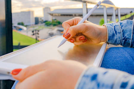 Outdoor online business technology. Student woman work with laptop tablet, computer in nature outside. Person girl sitting in summer park with people. Happy hipster young distance learning concept.の写真素材
