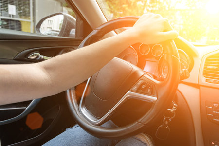 Travel car trip on road at sunset. Happy young woman have fun driving inside vehicle in summer sunny...