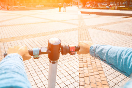 Kick scooter. Electric city bike using from girl. Urban lifestyle background. Modern and ecological...
