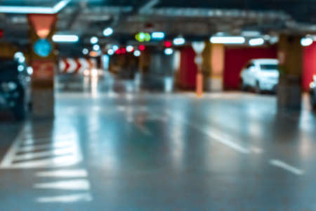 Garage car blurred. Car lot parking space in underground city garage. Empty road asphalt background in soft focus. Concrete skeleton for parking car.の写真素材