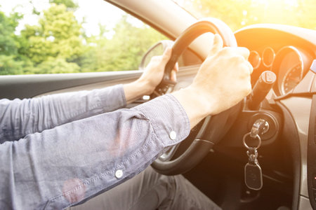Business man driving car. Travel car trip on road at sunset. Happy young man have fun ride inside...
