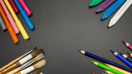 Blackboard school. Education accessories with colorful pencils, chalk, brushes on dark school...