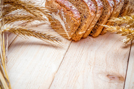 Traditional bread. Fresh loaf of rustic traditional bread with wheat grain ear or spike plant on...