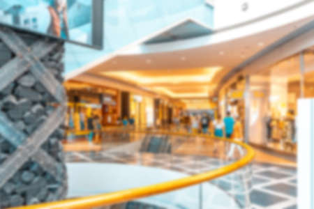 People shopping center blurred background. Interior of retail center store in soft focus. People shopping in modern commercial mall center. Fashion market hallの写真素材