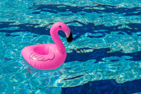 Summer concept background. Pink inflatable flamingo in pool water for summer beach background. Pool float partyの写真素材