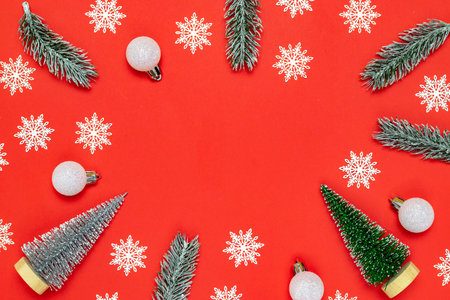 Holiday winter red. White snowflakes, fir tree, silver balls in Christmas composition on red...