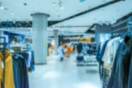 People shopping center blurred background. Interior of retail center store in soft focus. People shopping in modern commercial mall center. Fashion market hallの写真素材