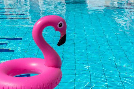 Flamingo icon. Pink inflatable flamingo in pool water for summer beach background. Trendy summer...