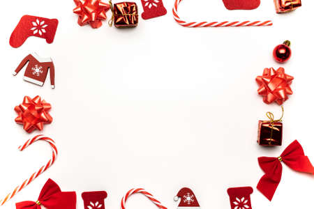 Holiday winter white. Stocking, gifts, winter tree, ribbon and bow in shape frame on white background for greeting card. Flat lay, top view, copy spaceの写真素材